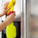 persona con spruzzino che pulisce