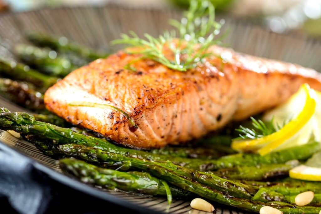 filetto di salmone marinato con limone e spezie su letto di asparagi