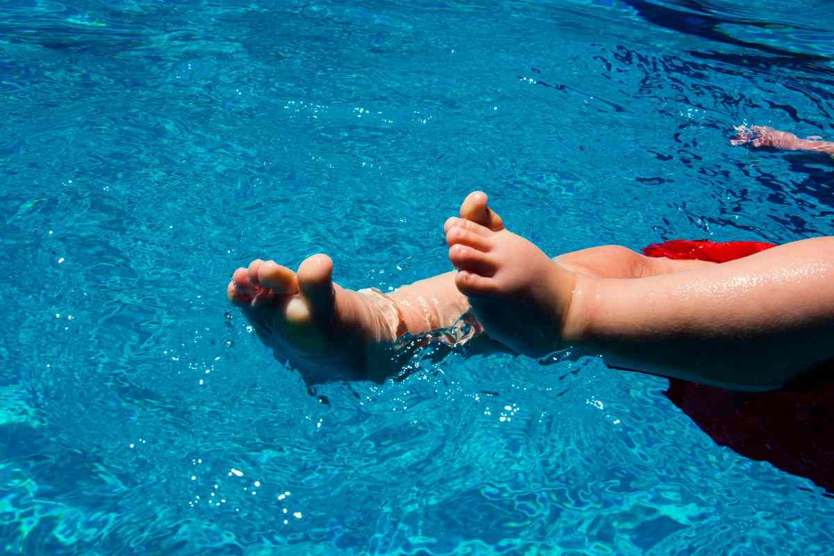 piedini di un bimbo piccolo in piscina