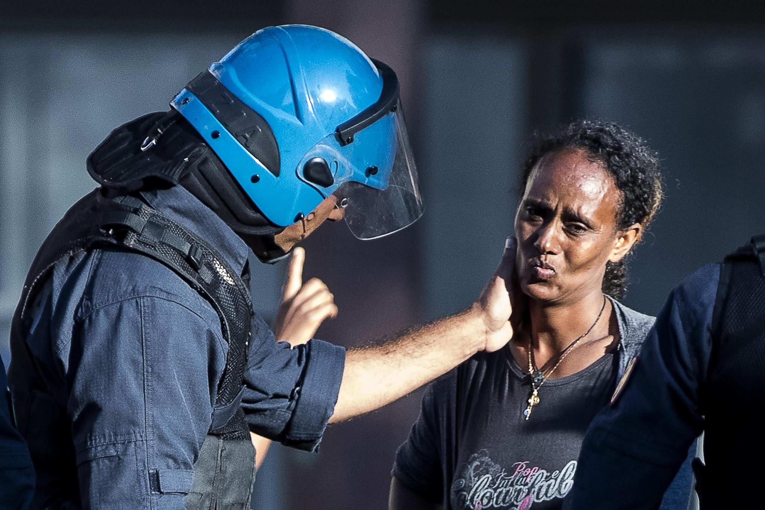 Sgomberi di Roma,  la carezza del poliziotto alla migrante eritrea: la foto-simbolo del dramma