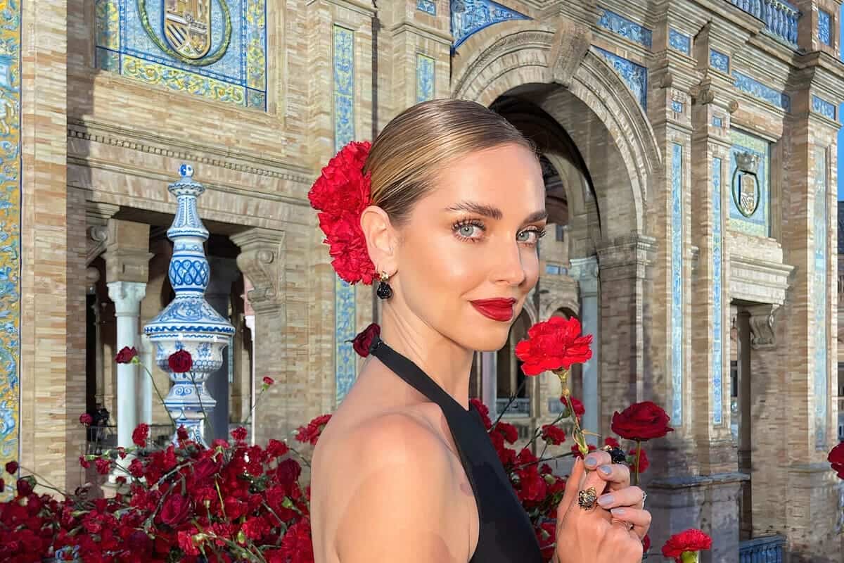 Chiara Ferragni a Siviglia per Dior con chignon basso e fiori rossi