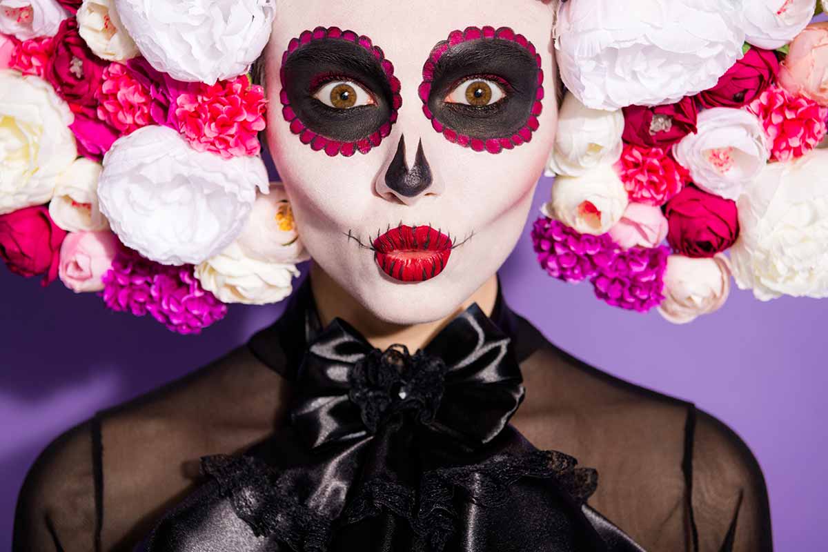 Ragazza mascherata con un trucco di carnevale ispirato al dia de los muertos