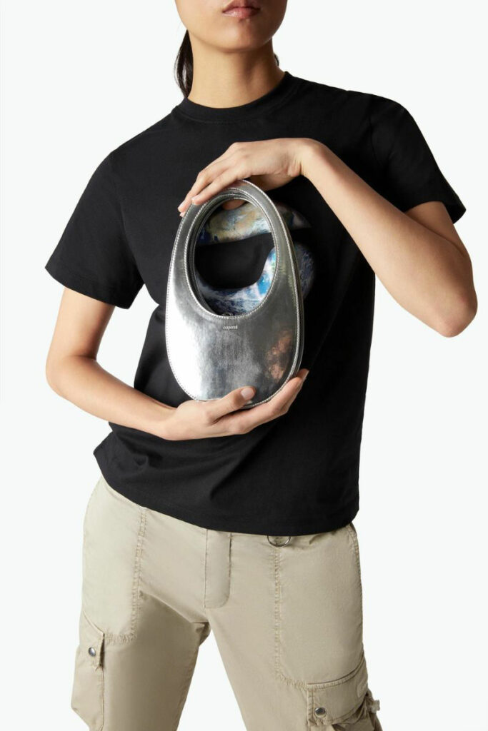 ragazza con t-shirt nera e mini bag ovale argentata Coperni