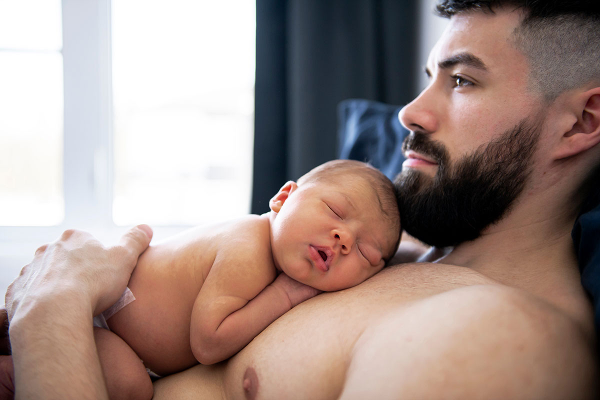 Papà con in braccio un bambino appena nato