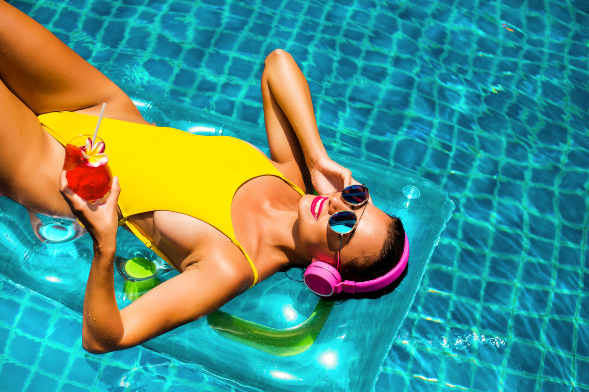 Donna in piscina con un costume da bagno giallo
