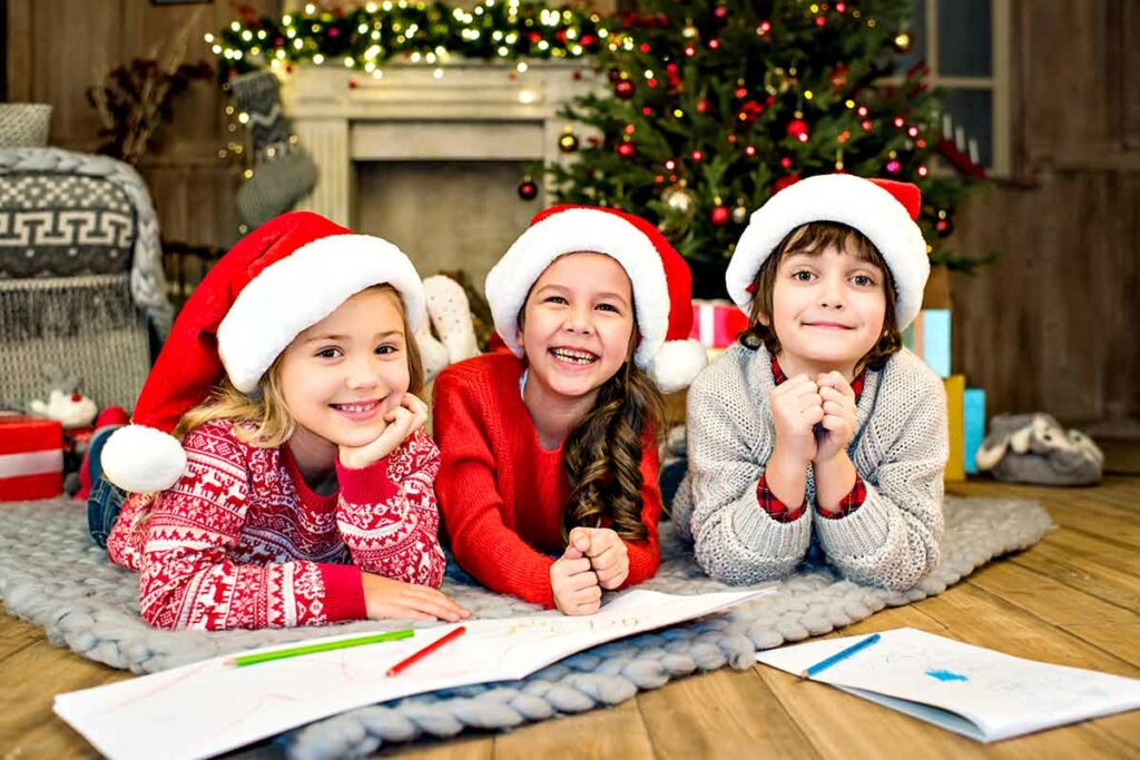 bambini-sorridenti-con cappelli natalizi e colori