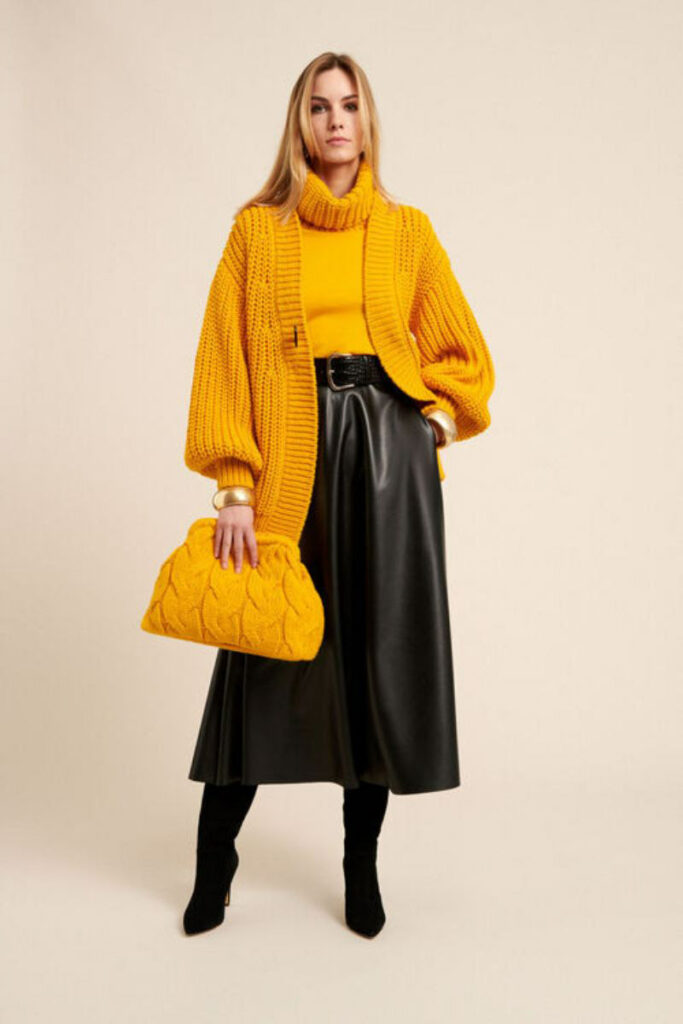 donna con gonna in pelle e maglione giallo