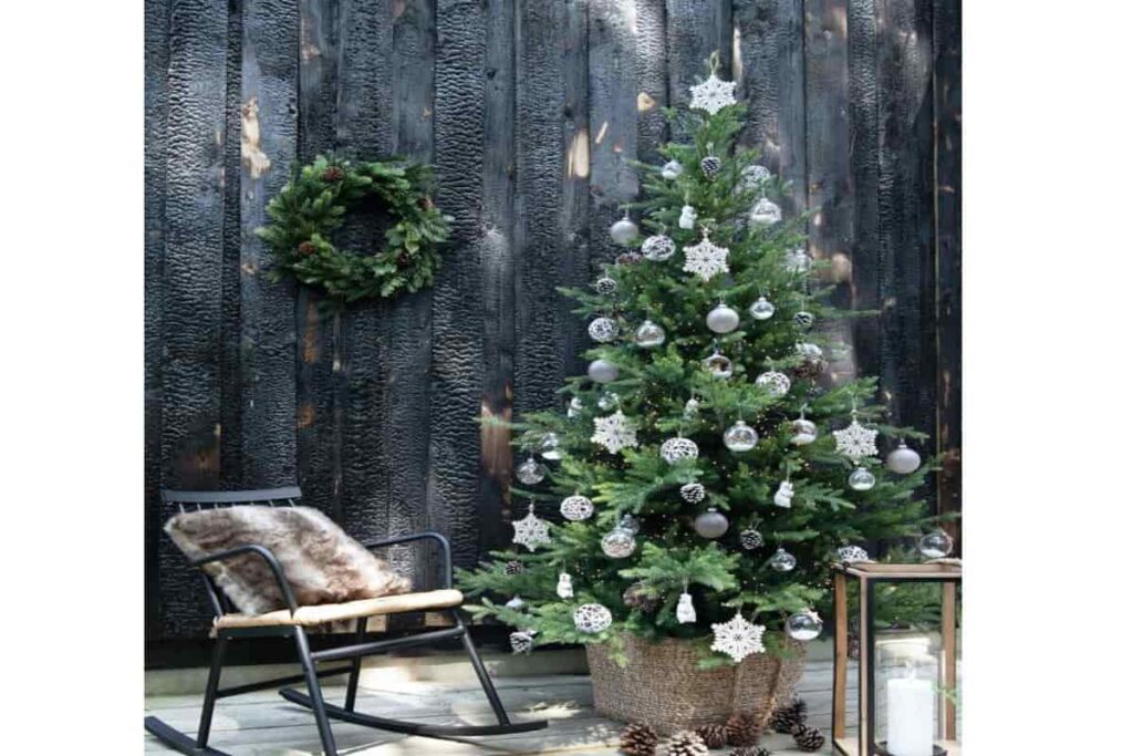 albero di natale verde con palline trasparenti con sedia a dondolo 