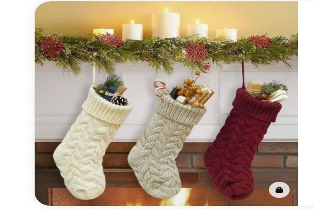 calze befana realizzate in maglia con regali e caramelle all'interno, appese al camino, di colore bianco, grigio e rosso