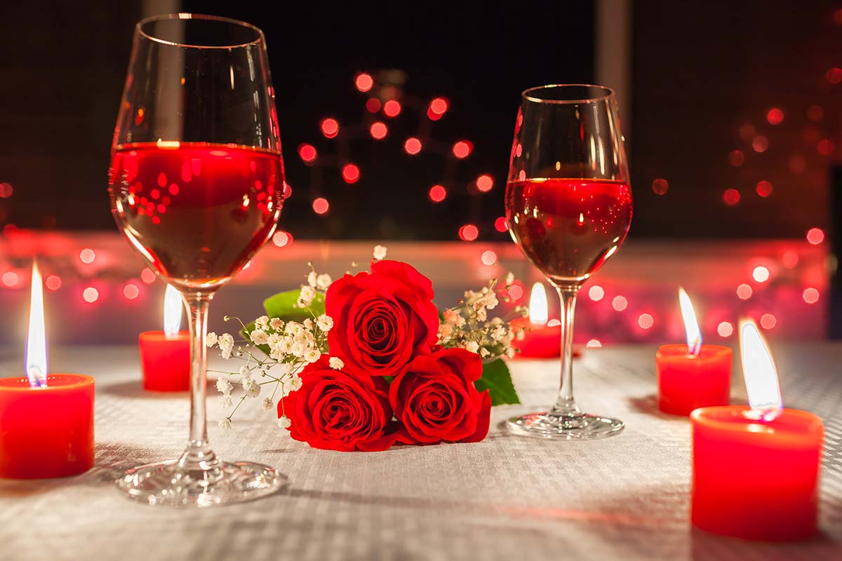 Tavola apparecchiata con rose rosse per una cena romantica San Valentino