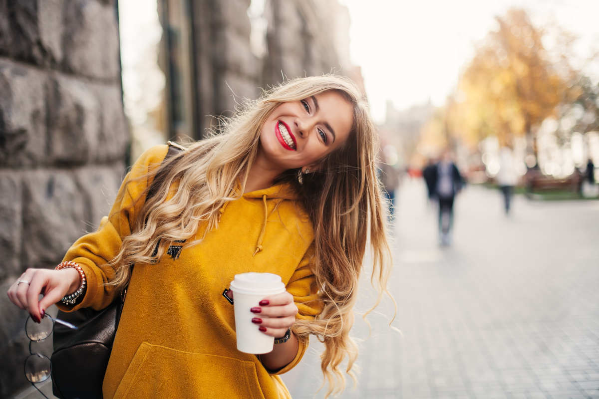ragazza sorridente con felpa gialla e occhiali
