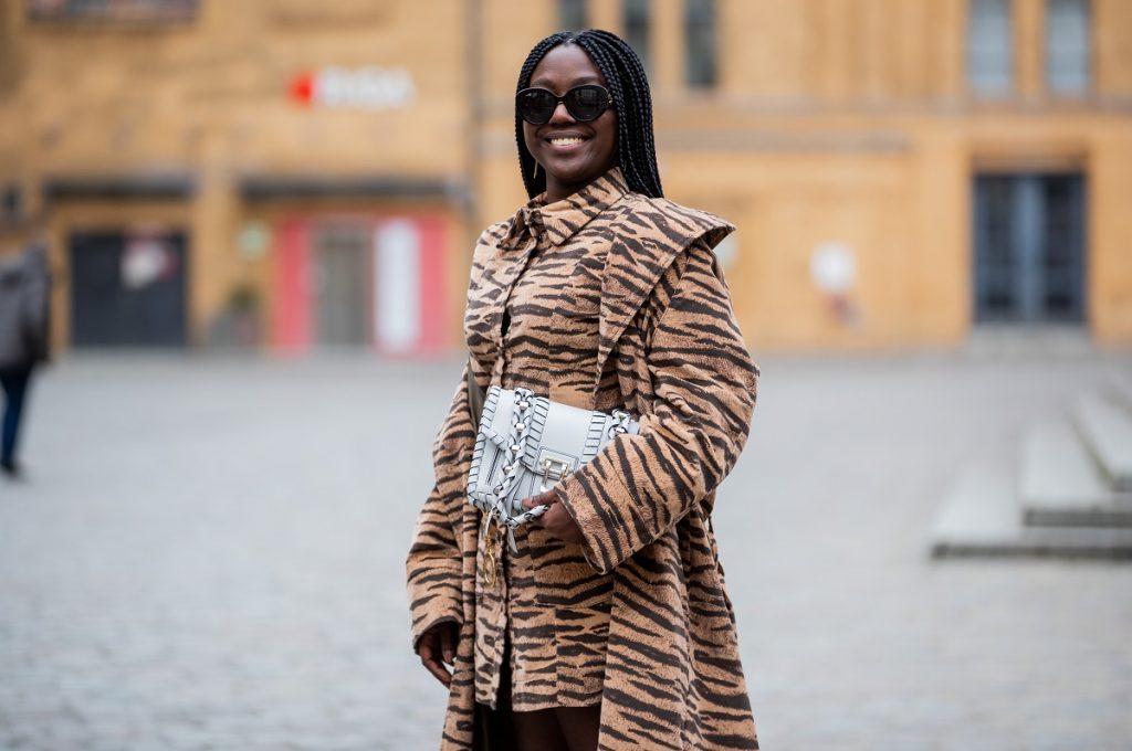 Lois Opoku è visto indossare abito e cappotto con stampa animalier Baum und Pferdgarten, borsa Proenza Schouler bianca, occhiali da sole Burberry durante la Mercedes-Benz Fashion Week di Berlino gennaio 2021 il 19 gennaio 2021 a Berlino, Germania