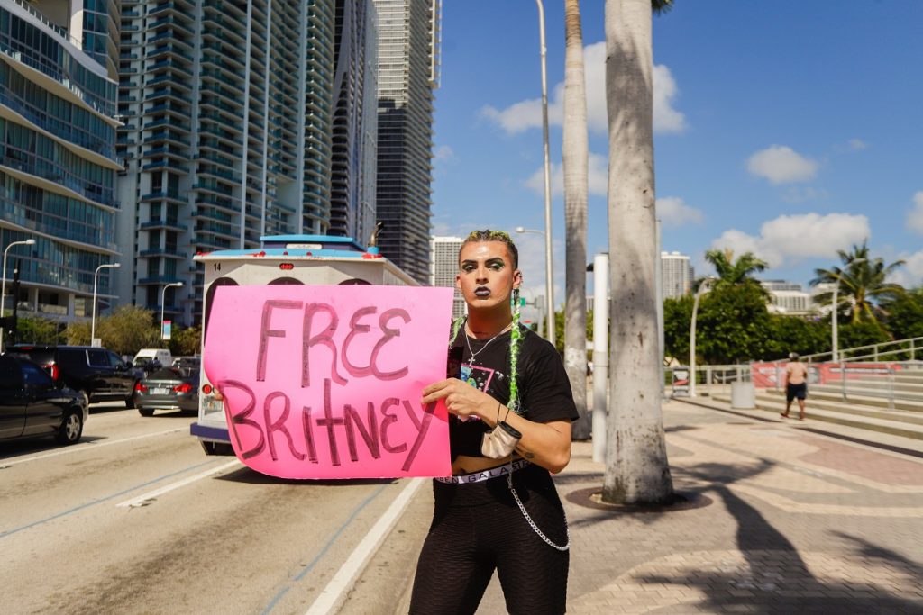 Un sostenitore di Britney Spears tiene un cartello durante una protesta #FreeBritney fuori dall'American Airlines Arena l'11 febbraio 2021 a Miami, Florida. La Spears è stata collocata in una tutela gestita da suo padre, Jamie Spears, e un avvocato, che controlla i suoi beni e rapporti d'affari, a seguito del suo ricovero involontario per cure mentali nel 2008