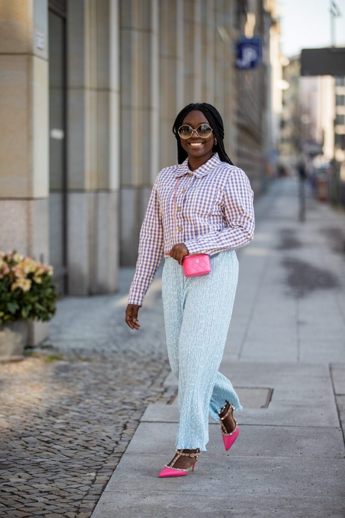 Lois Opoku è visto indossare pantaloni e giacca Monki, micro borsa Chanel in rosa, tacchi Valentino il 22 febbraio 2021 a Berlino, Germania