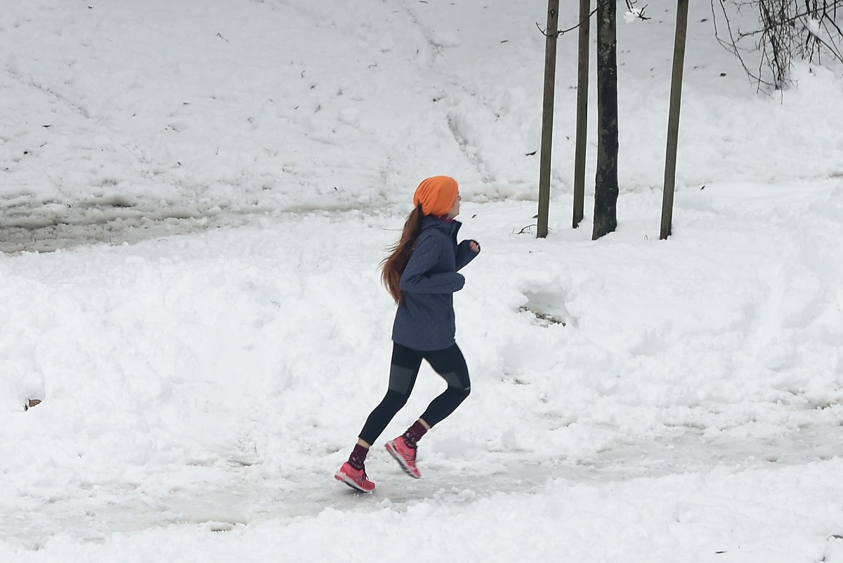 allenarsi al freddo - Una donna corre sul Monte Stella dopo la nevicata il 28 dicembre 2020 a Milano, Italia. Sebbene le Alpi fossero già coperte, gran parte del nord Italia a quote più basse ha ricevuto una coltre di neve quando il tempo è diventato più freddo.