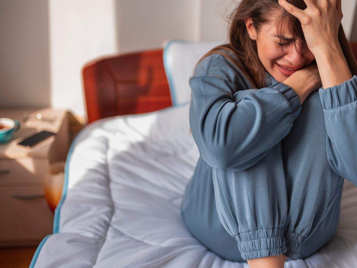 ragazza seduta sul letto che piange