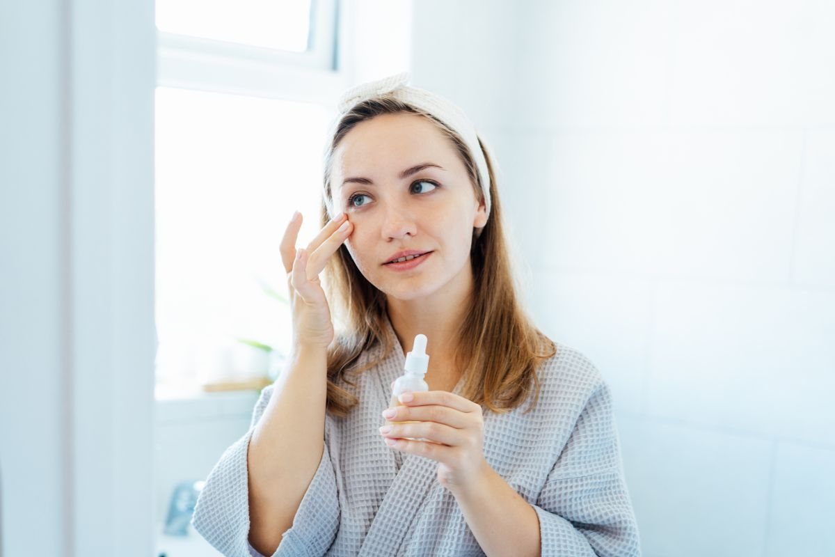 persona che applica prodotto sul viso