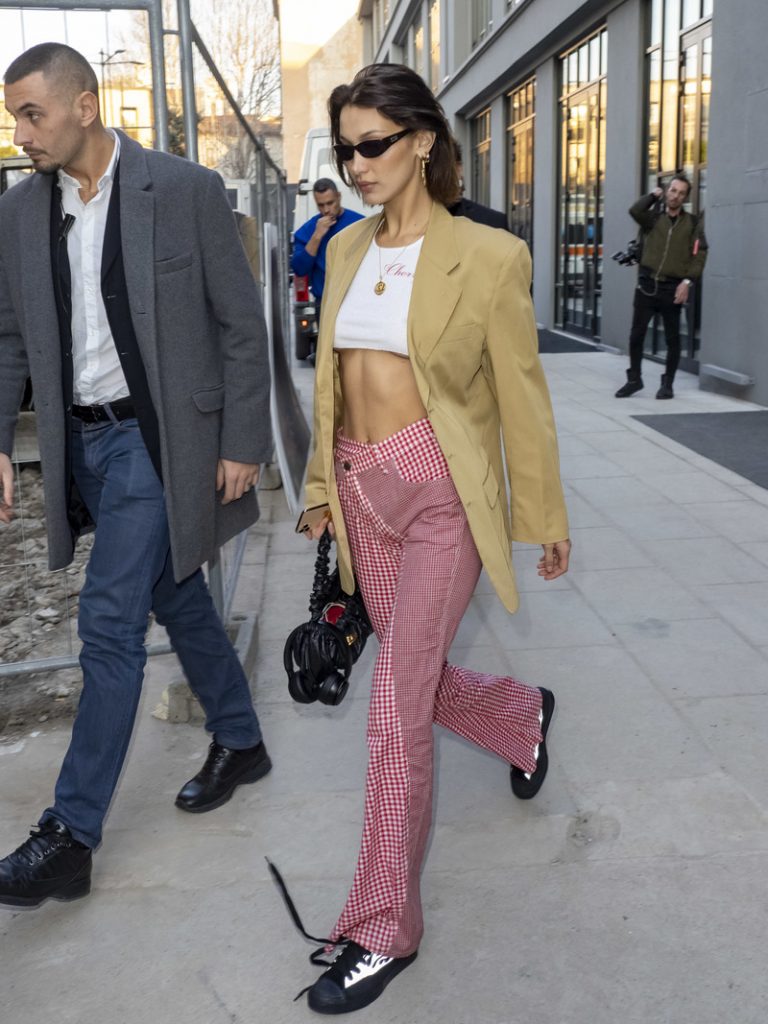 Bella Hadid indossa un paio di pantaloni a quadri che ha abbinato a un crop top e a una giacca over