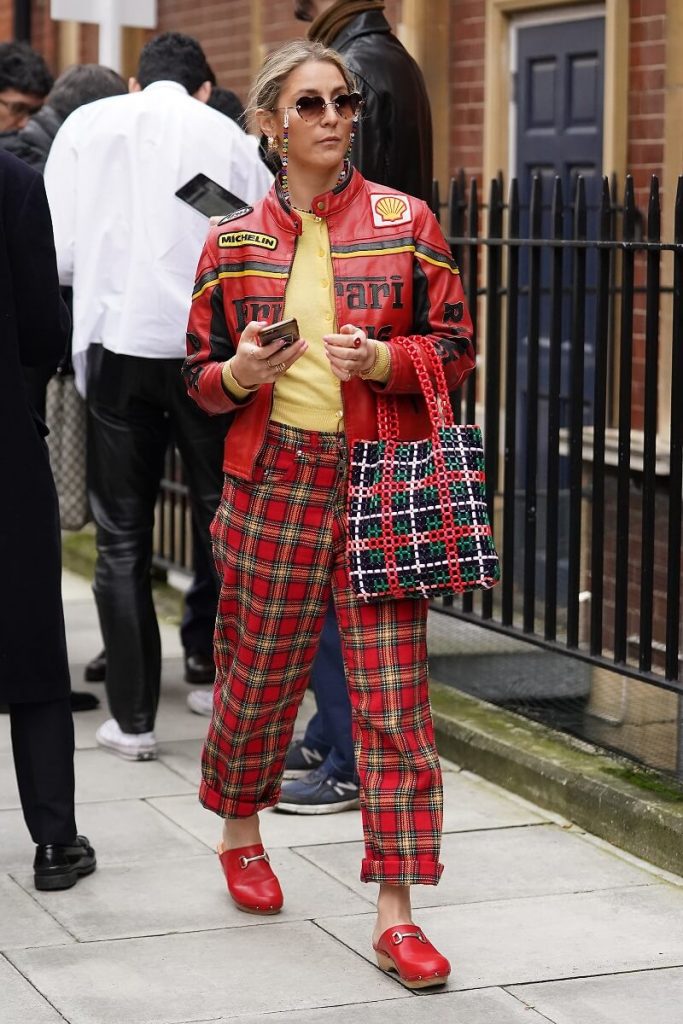 L'ospite che indossa una giacca di pelle rossa Ferrari, pantaloni scozzesi e zoccoli rossi frequenta JW Anderson alla Yeomanry House durante la London Fashion Week, febbraio 2020, il 17 febbraio 2020 a Londra, Inghilterra