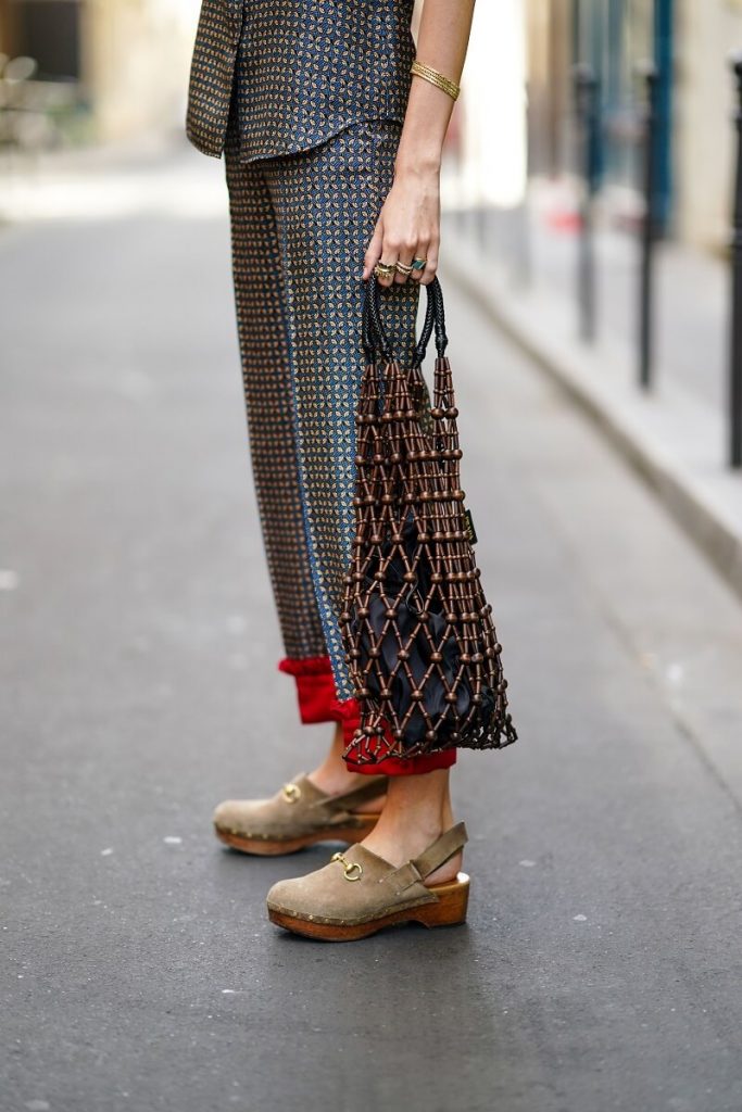 Estelle Chemouny indossa una giacca senza maniche Prada con piccoli motivi geometrici stampati e un colletto arricciato rosso, pantaloni corti Prada con polsini arricciati rossi, una borsa in rete a rete Prada a rete, un braccialetto dorato, scarpe beige Gucci, l'8 luglio 2020 a Parigi, Francia
