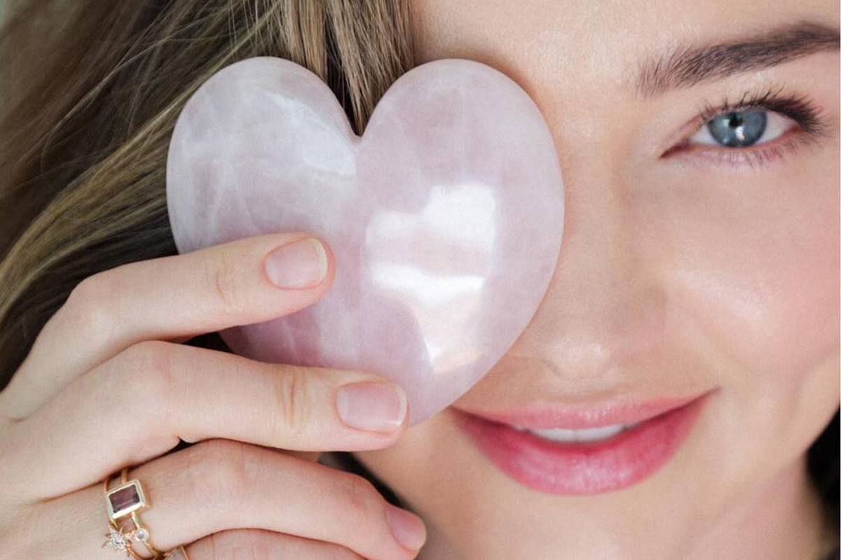 primo piano di Miranda Kerr con quarzo rosa in mano