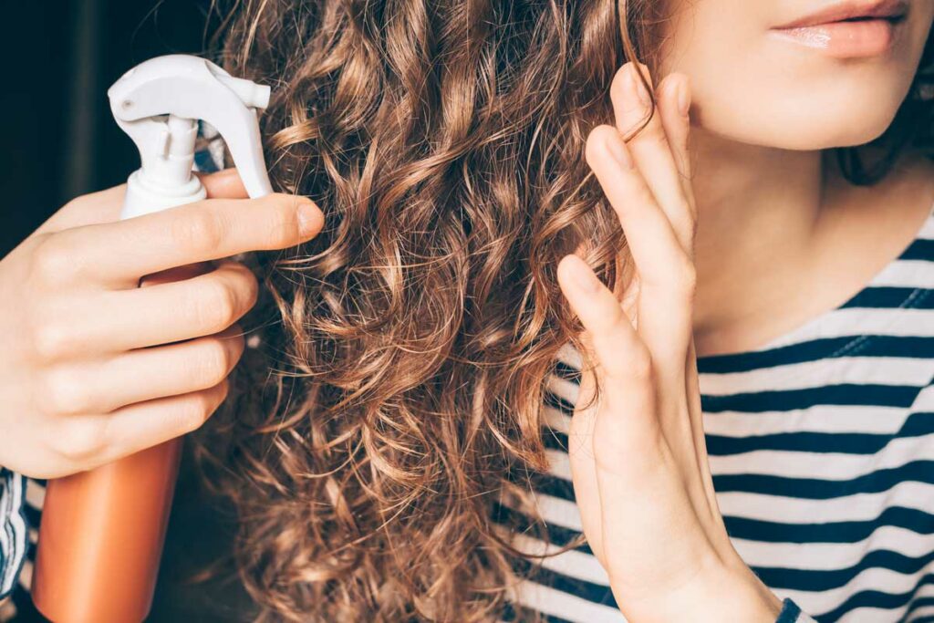 donna con spray per capelli