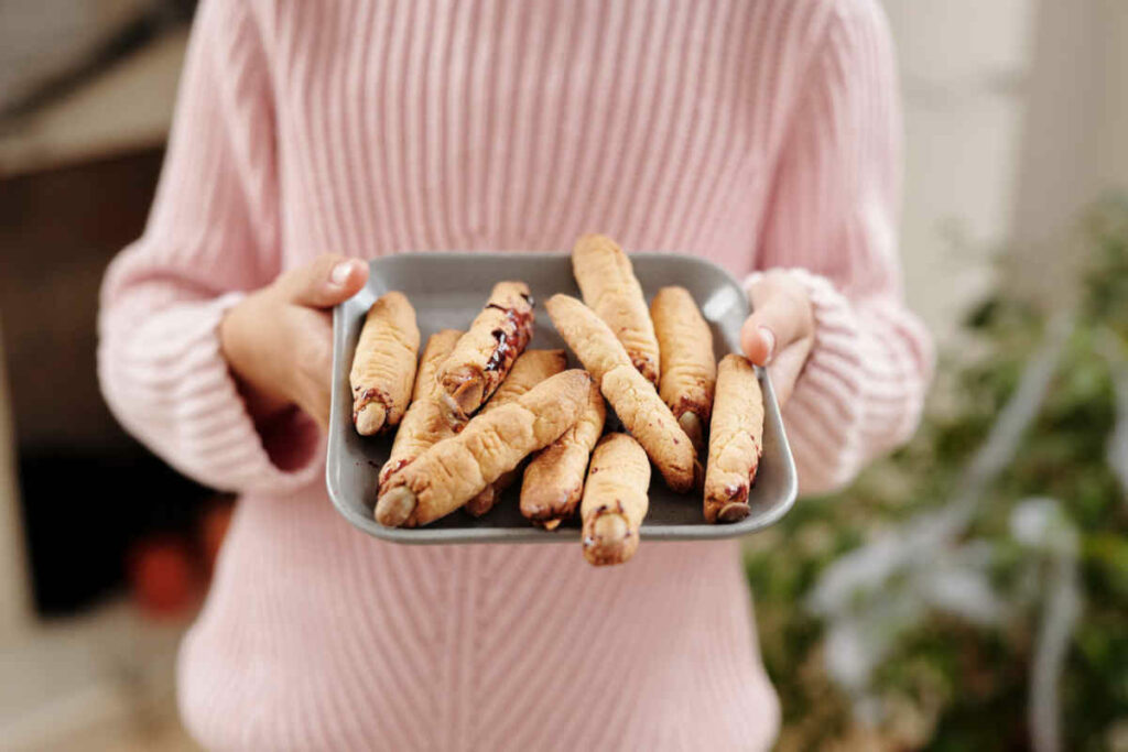 vassoio tenuto in mano da ragazza con snack dita di strega per halloween