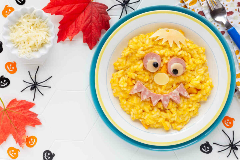 piatto con risotto alla zucca decorato a forma di faccia per il menu halloween