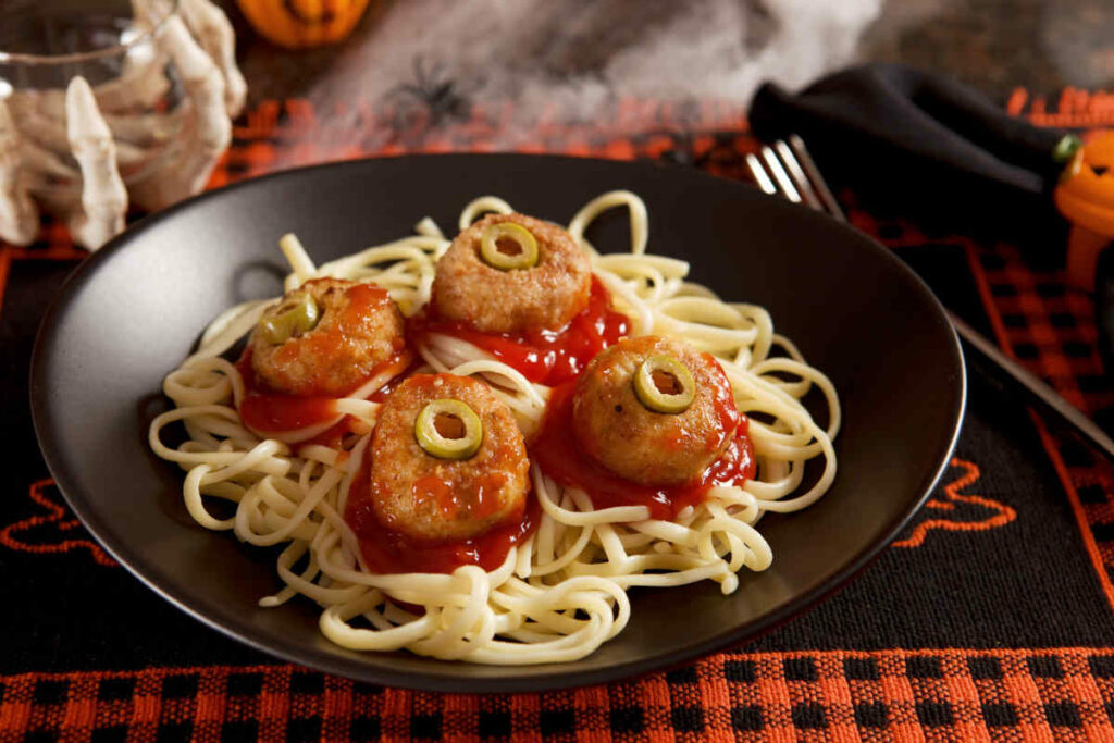 piatto nero con spaghetti al pomodoro e polpette a forma di occhi