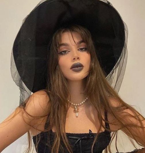 ragazza con cappello da strega e rossetto nero