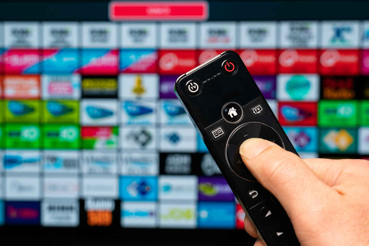 telecomando e tv accesa con i programmi di stasera in tv