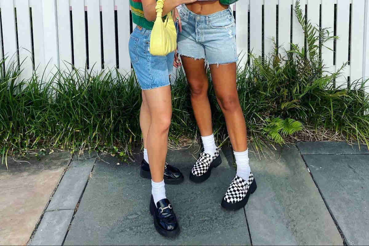 ragazze con shorts denim e mocassini in pelle neri e a scacchi bianchi e neri