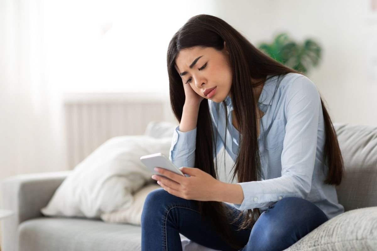 persona sul divano che guarda lo smartphone