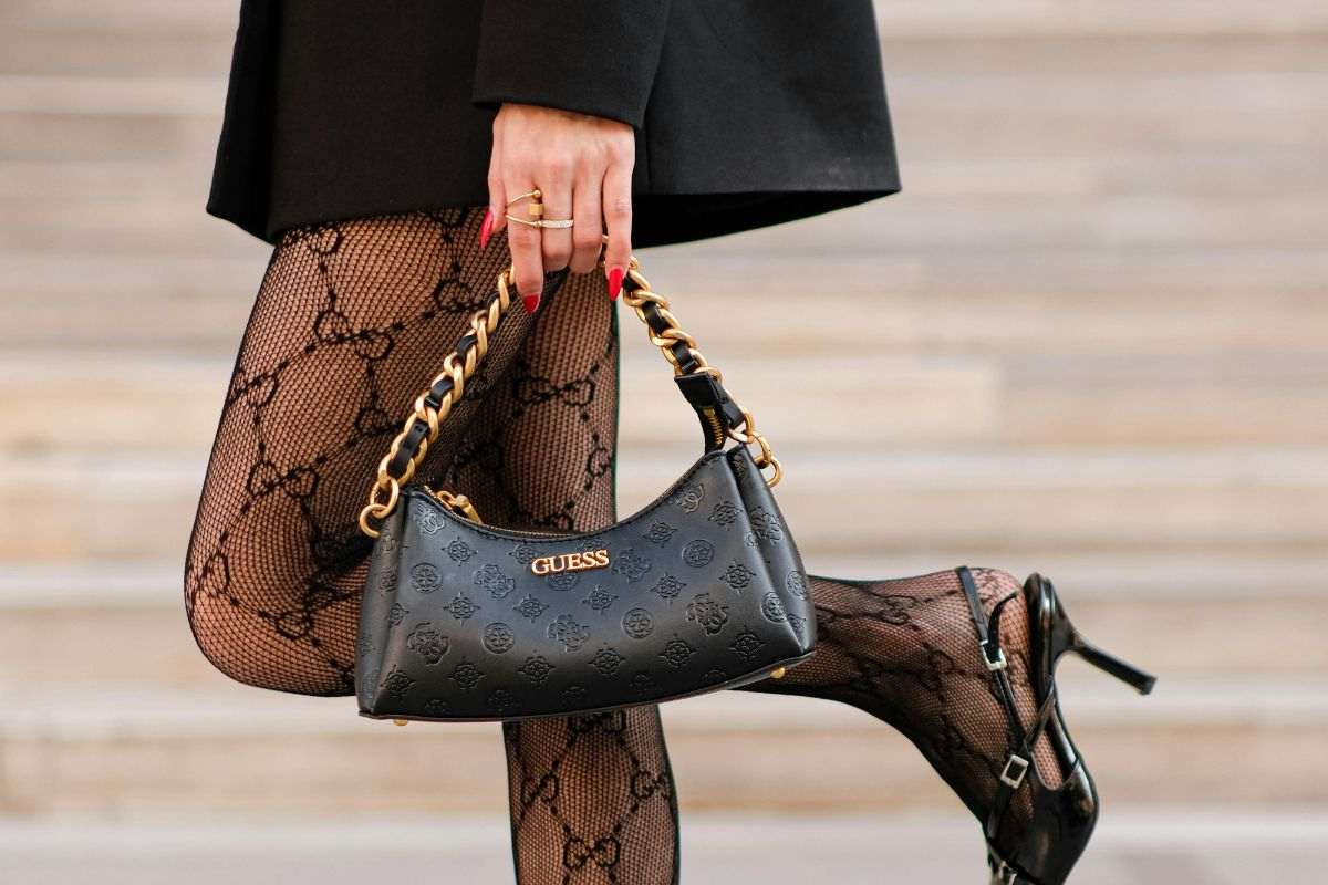 gambe di una ragazza con calze e mini bag