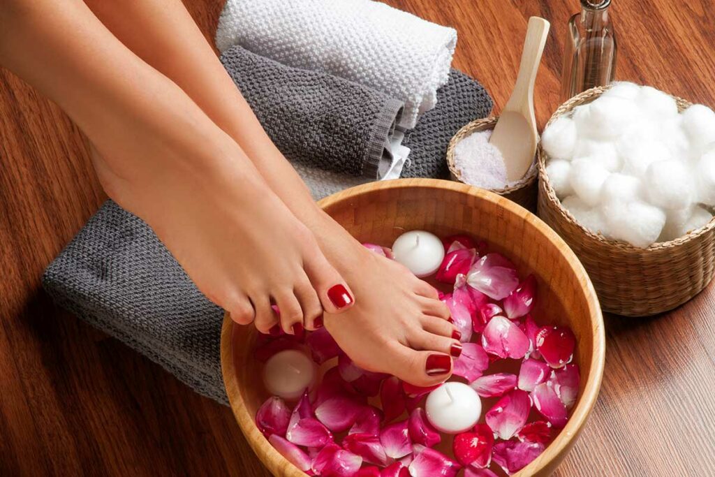 Ragazza che fa il pedicure a casa da sola