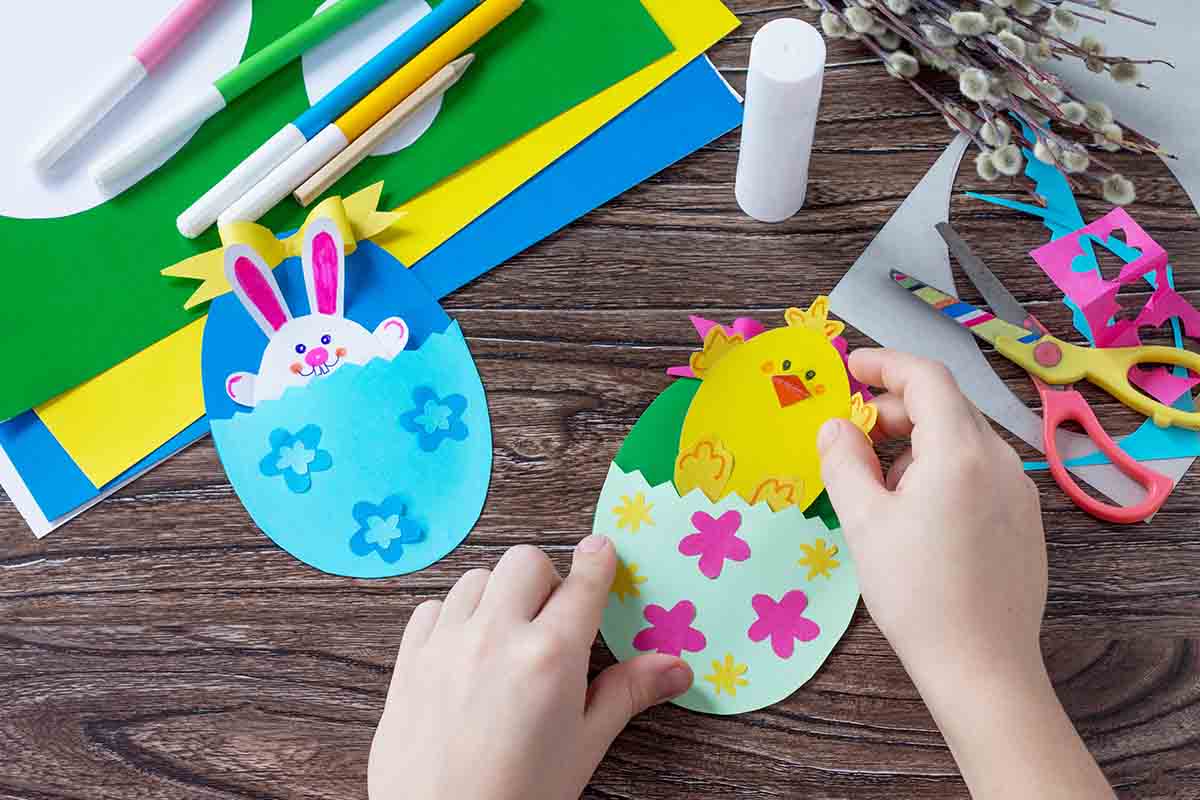 bambini che colorano e lavorano le uova di pasqua stampate