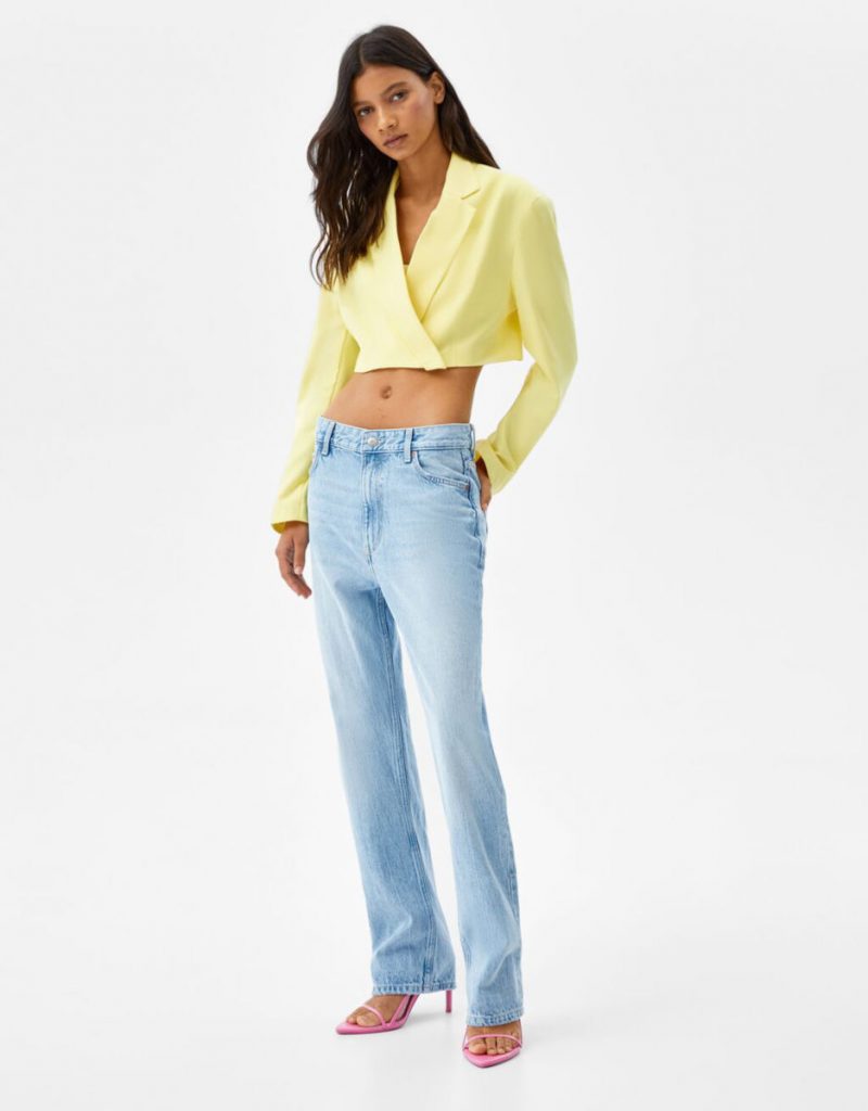 donna con giacca crop gialla e jeans