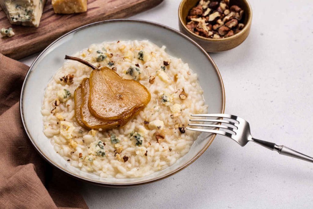 piatto fondo con risotto alle pere, con gorgonzola e noci tritate