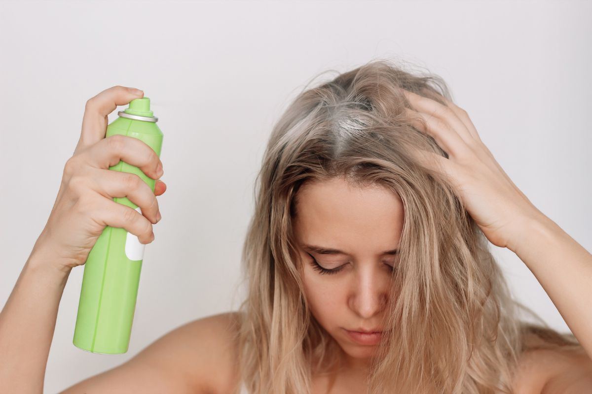 ragazza che applica shampoo secco sulla cute