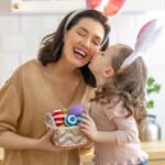 mamma e figlia con orecchie da coniglio e uova di pasqua colorate