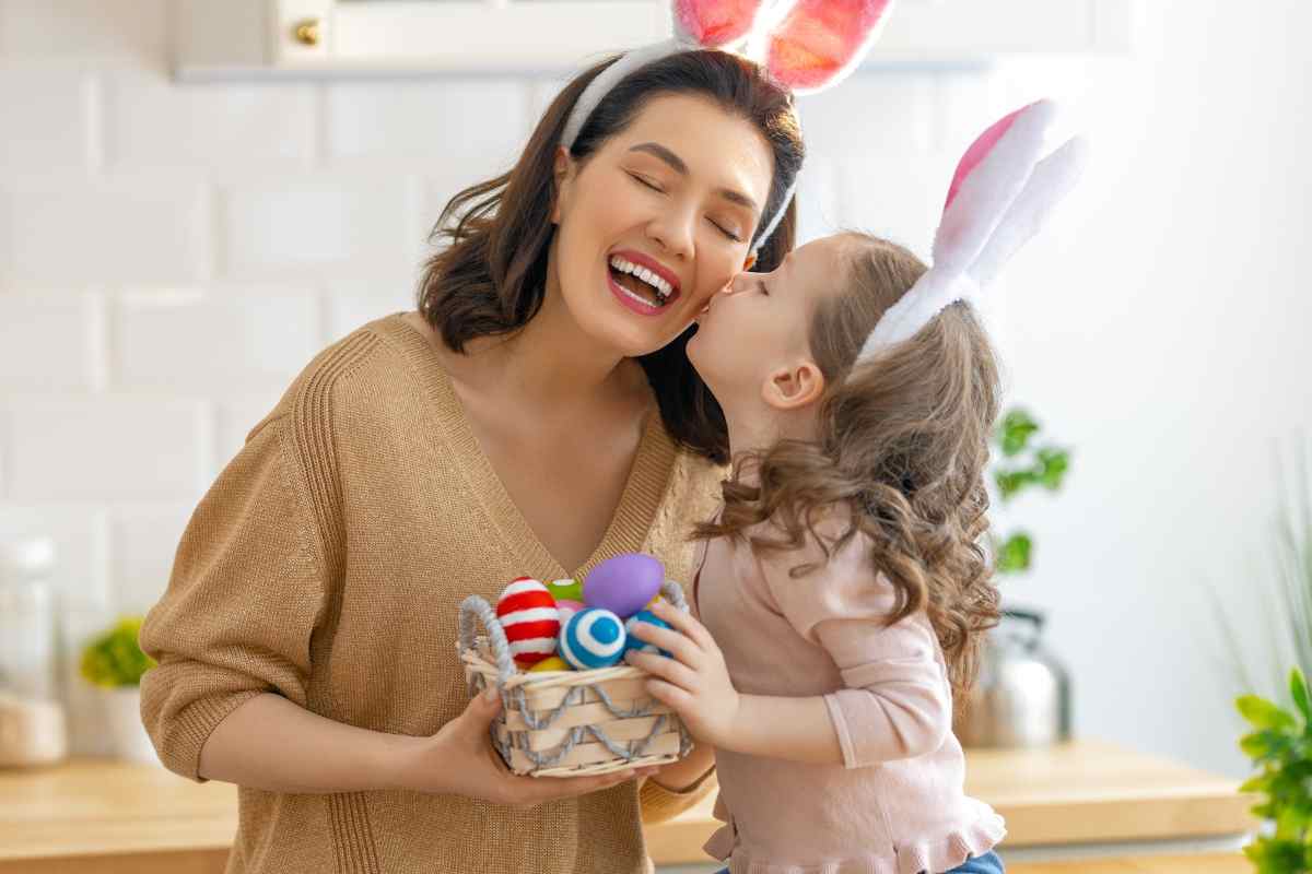 mamma e figlia con orecchie da coniglio e uova di pasqua colorate