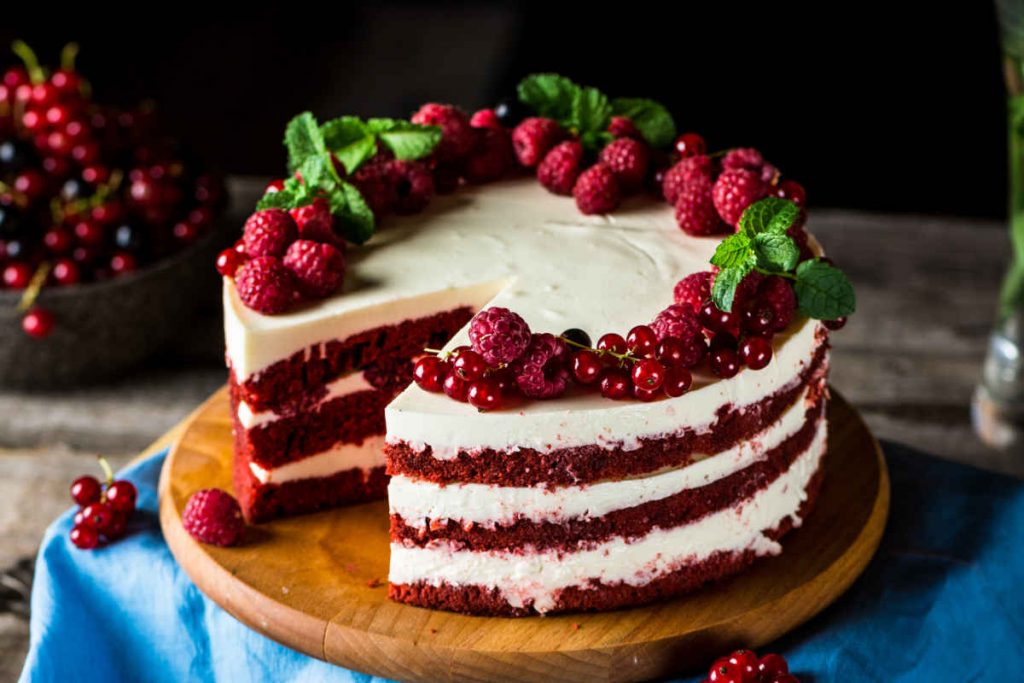 vassoio in legno con torta red velvet farcita con crema al formaggio e lamponi