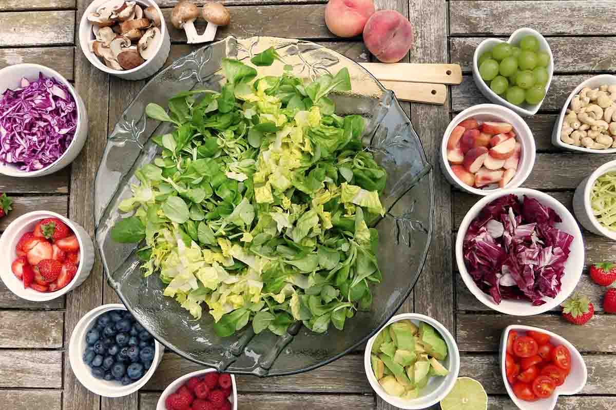 piatti di insalata, frutta e salumi