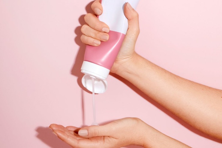 persona che spreme crema sulle mani