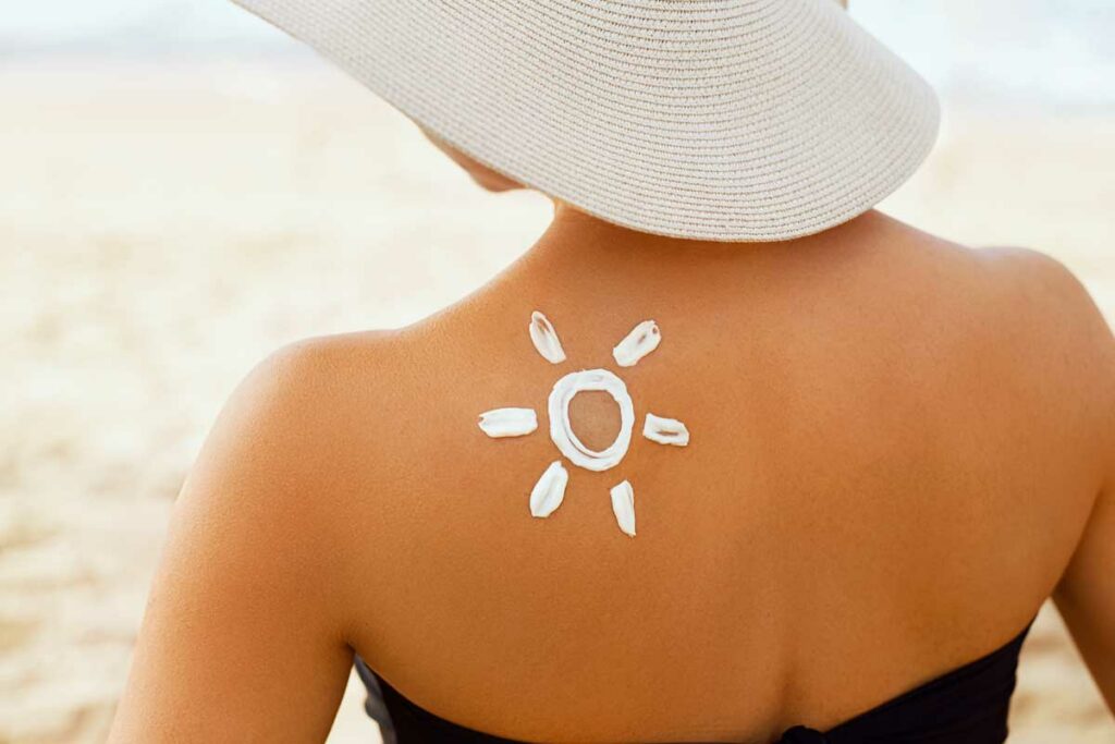 donna con crema solare sulla spalla