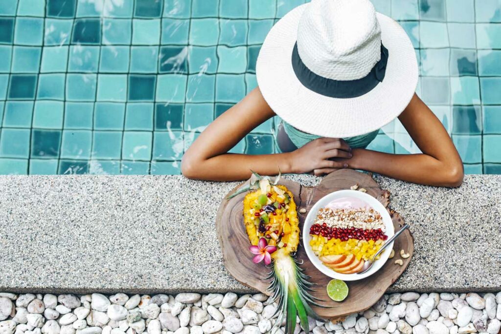 ragazza in piscina con frutta