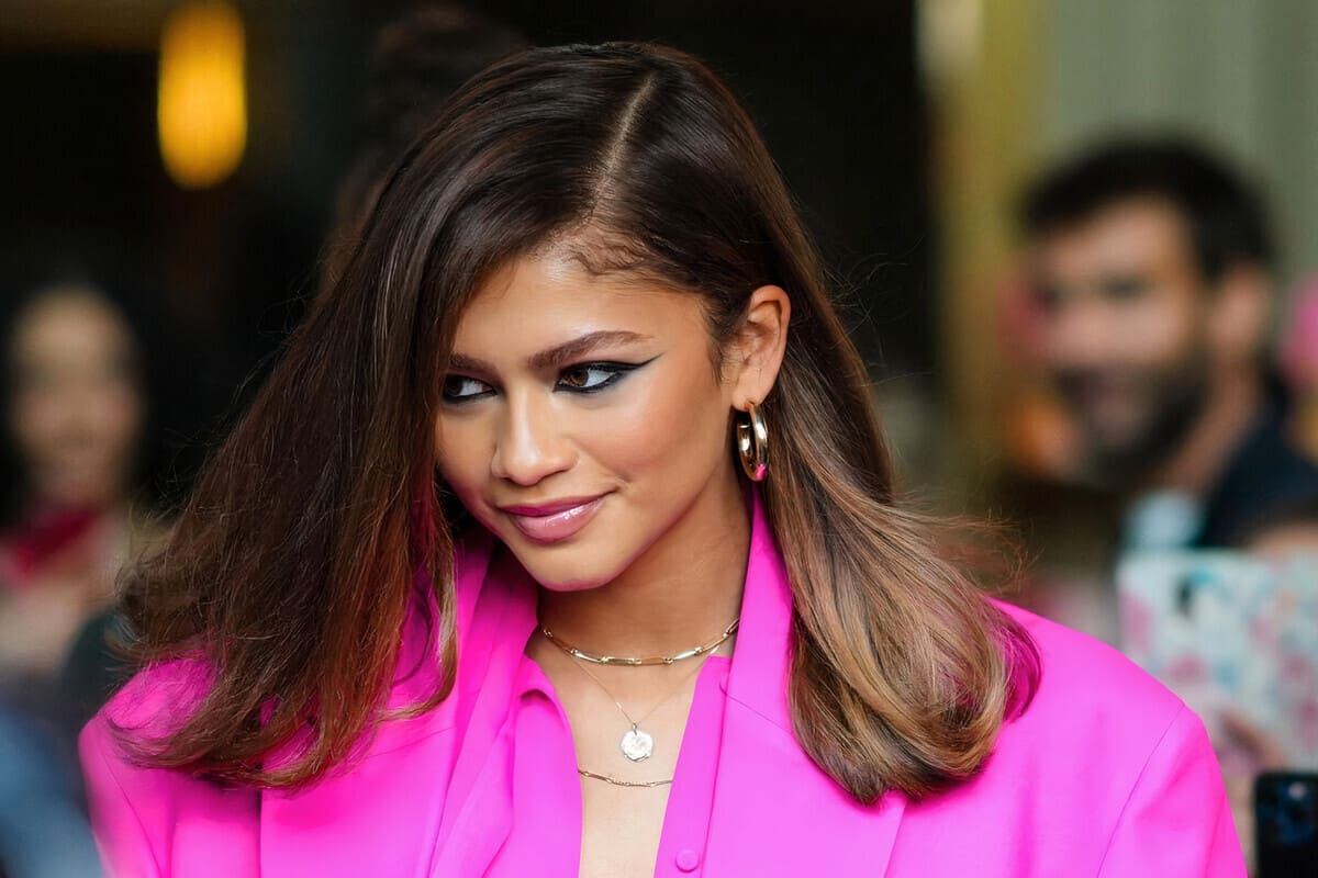 Zendaya con blazer ciclamino, kajal intenso e piega liscia voluminosa
