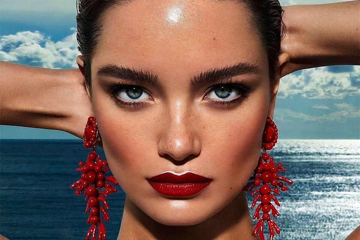 primo piano modella con trucco luminoso e mare alle spalle
