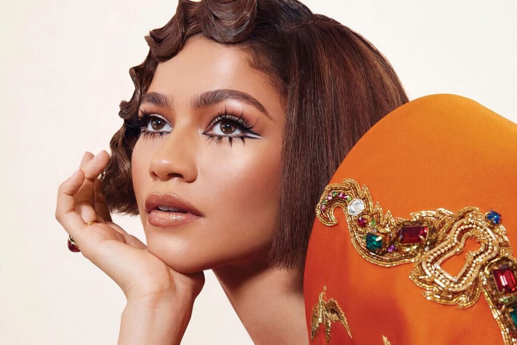 Zendaya con caschetto e ciuffo laccato, base luminosa e trucco occhi stravagante con ciglia finte texturizzate