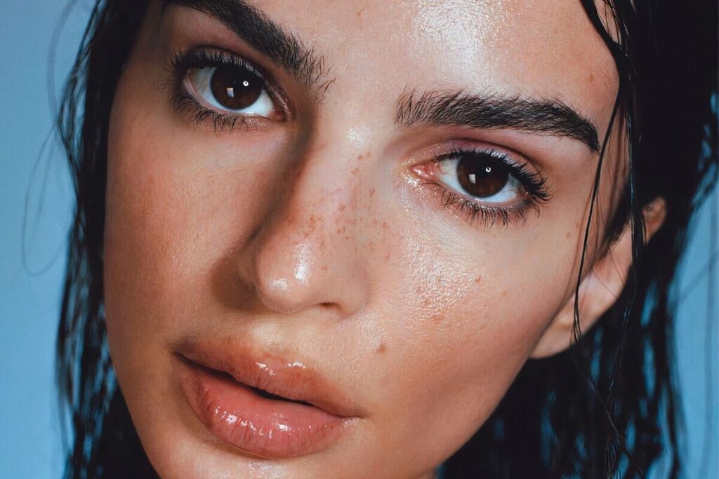 Primo piano di Emily Ratajkowski con capelli wet effect e gloss aranciato